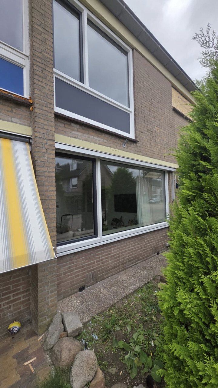 De nieuwe kozijnen en het antraciete paneel aan de voorzijde, gefotografeerd tijdens de afronding. Op andere plekken zijn nog werkzaamheden zichtbaar.
