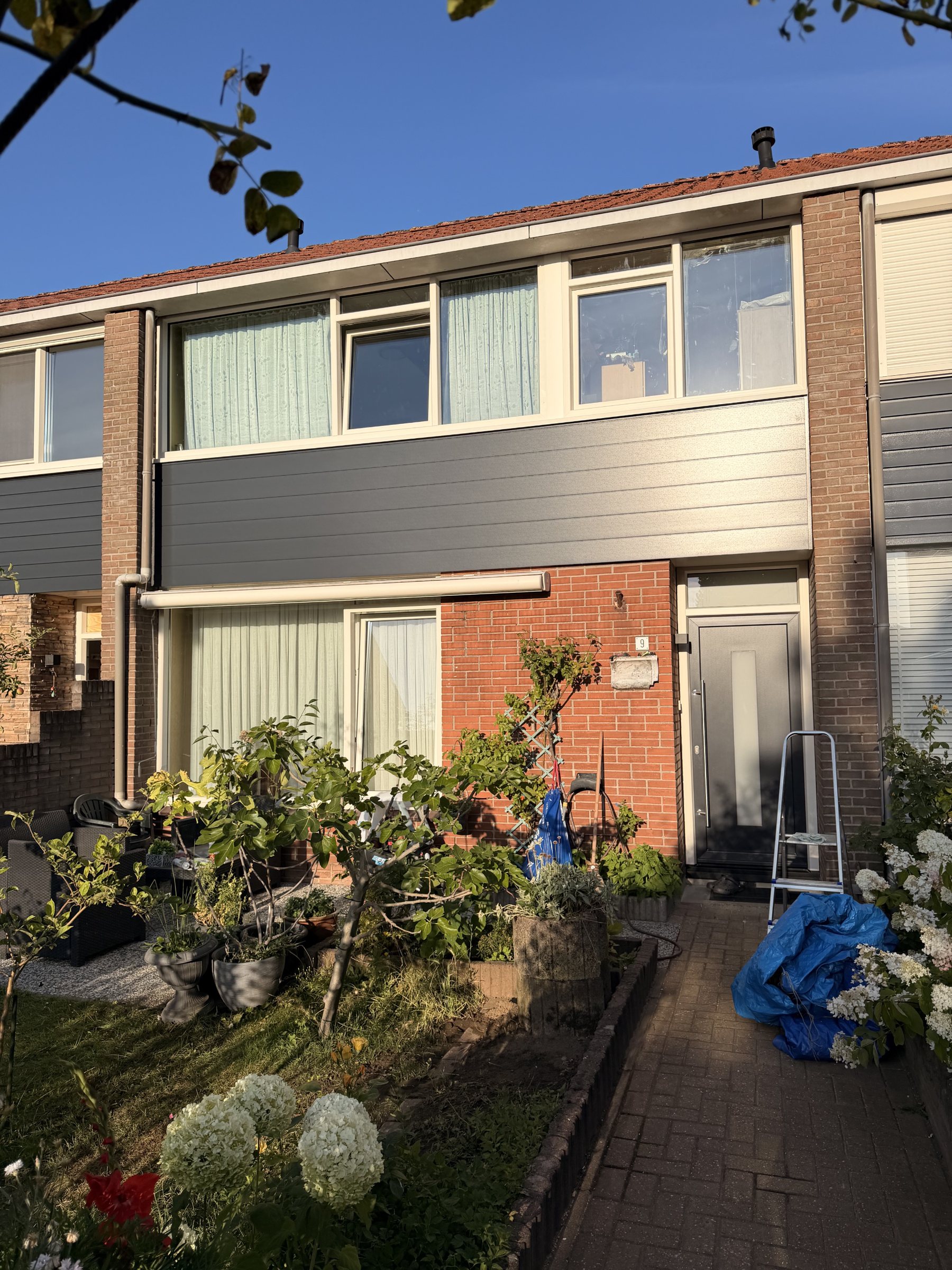 De andere woning in het project, met lichte kozijnen en vernieuwde gevelbekleding.
