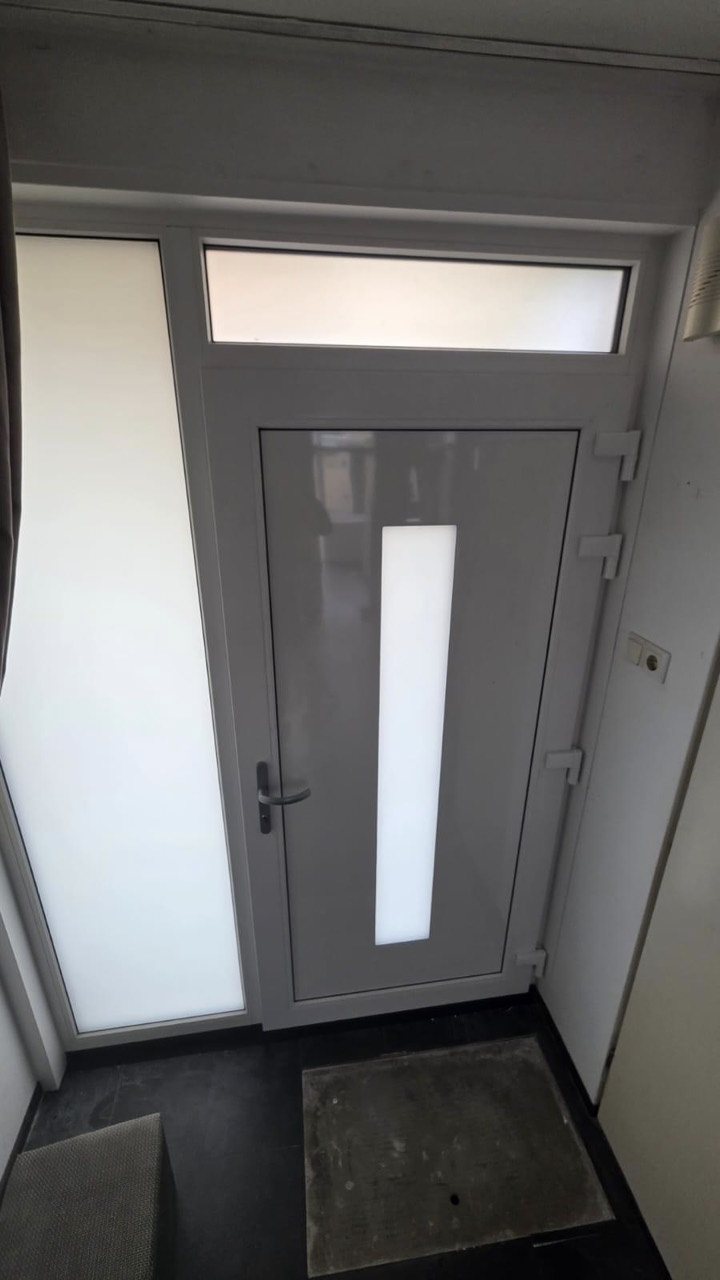 De binnenzijde van een voordeur met zijlicht en bovenlicht.