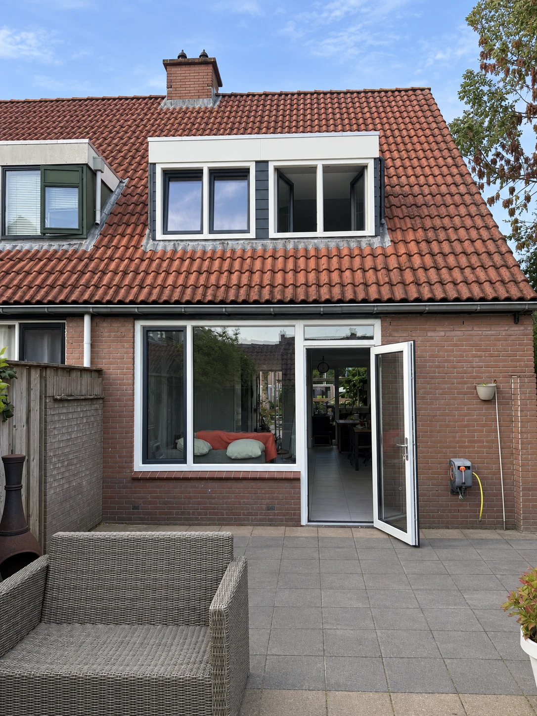 De geplaatste kozijnen en glazen achterdeur vormen samen een lichte, open achtergevel.