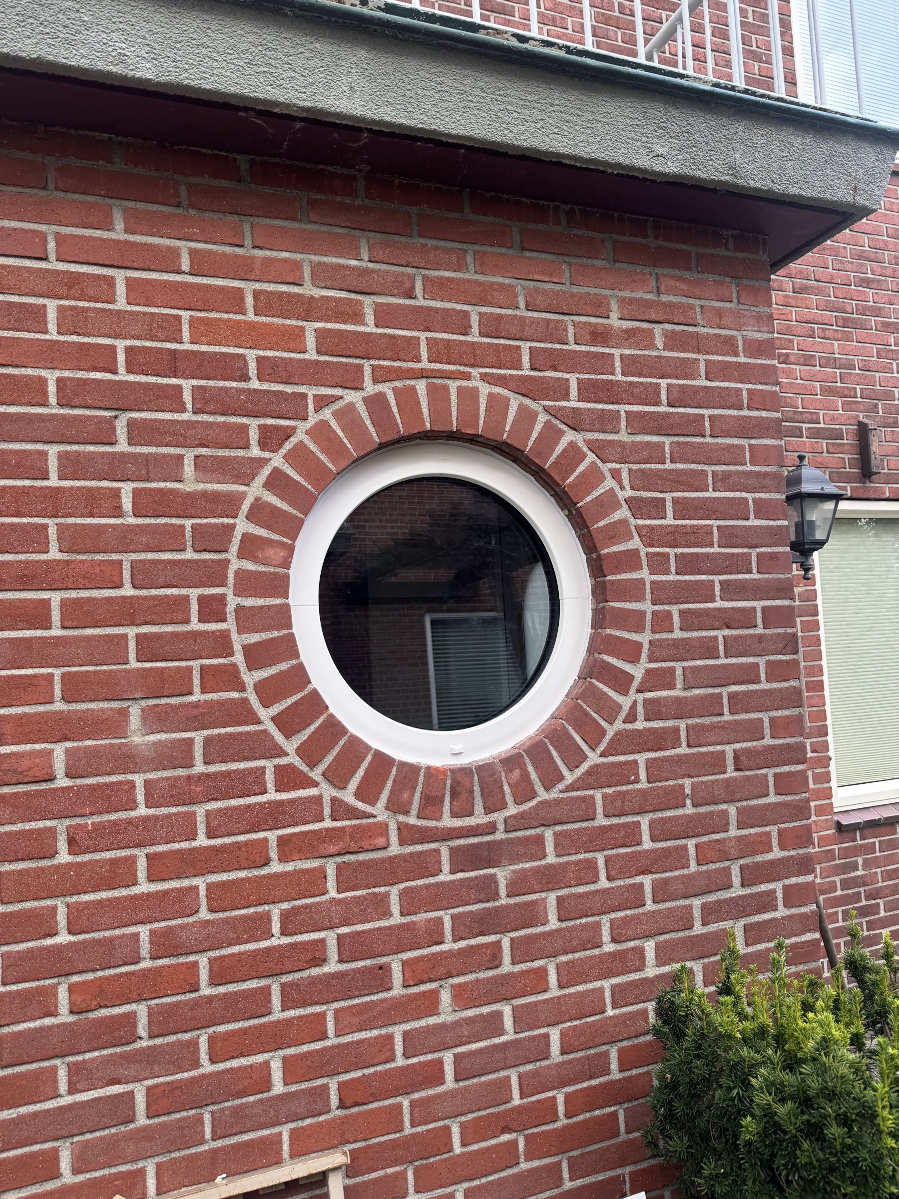 Een nieuw wit rond kozijn in de bestaande gemetselde omlijsting.